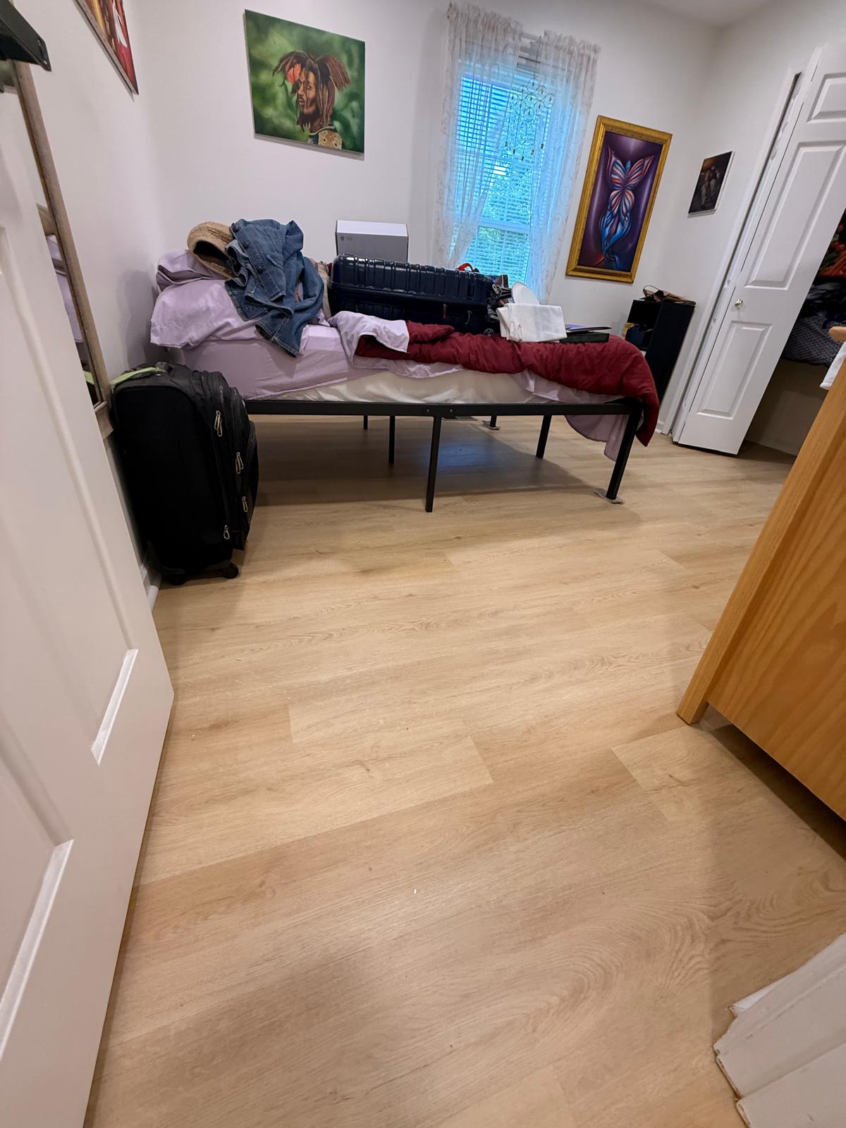 Finished guest bedroom with new light wood-look plank flooring, painted walls and fitted baseboards