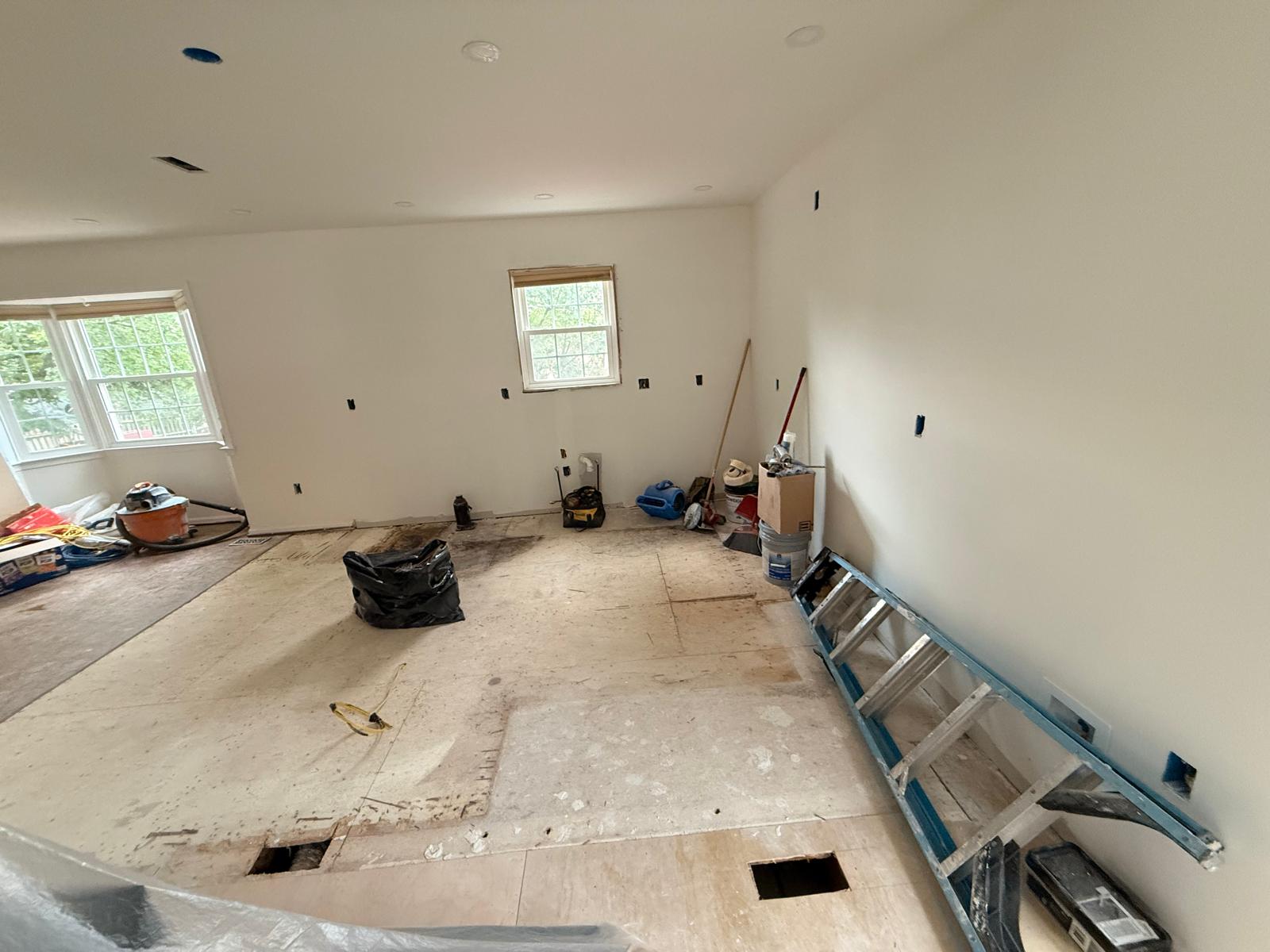Kitchen area with subfloor cut for ducts and plumbing, electrical rough-in and primed new drywall