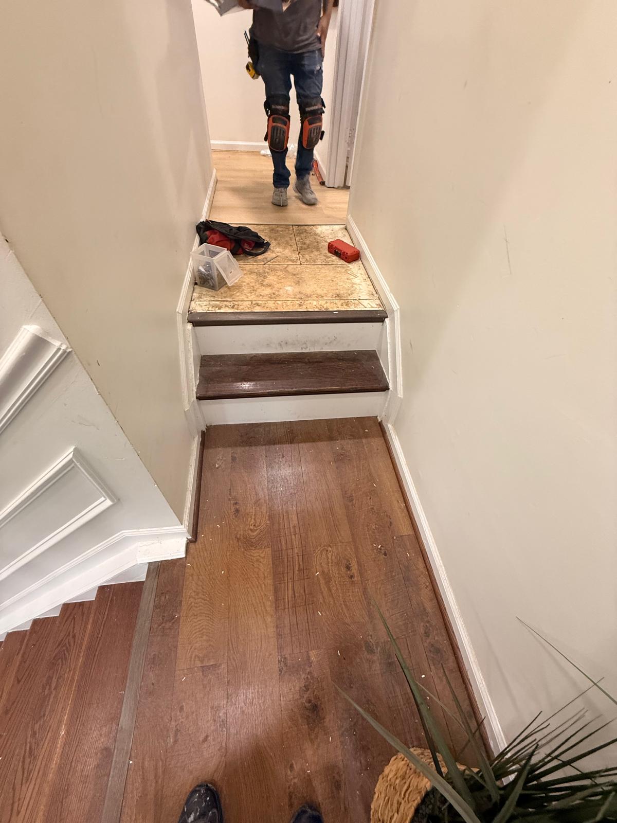 Split-level hallway and staircase landing with new plank flooring laid on the landings and upper hall